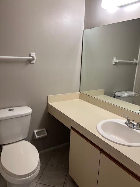 bathroom with vanity, tile patterned flooring, and toilet