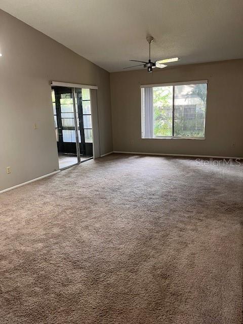 unfurnished room with lofted ceiling, ceiling fan, and carpet floors