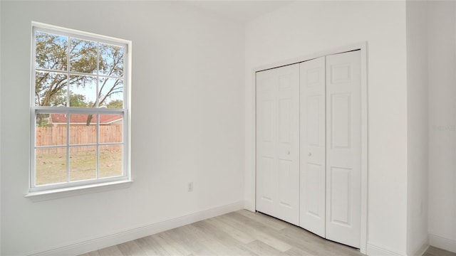 unfurnished bedroom with a closet and light hardwood / wood-style floors