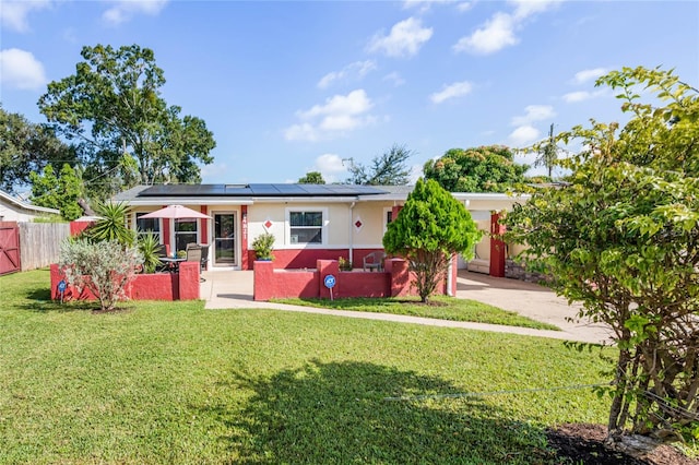 view of front of house with a front lawn and solar panels