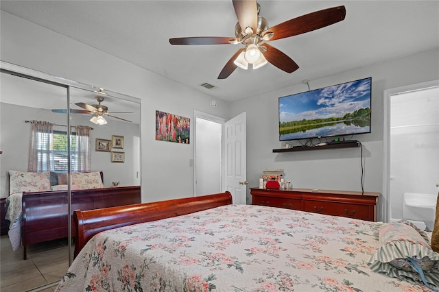 tiled bedroom with ceiling fan and a closet