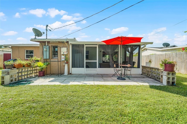 rear view of property featuring a patio, a sunroom, and a yard