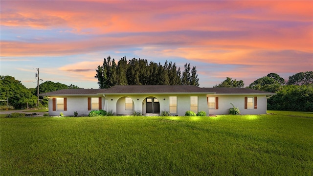 ranch-style home featuring a yard