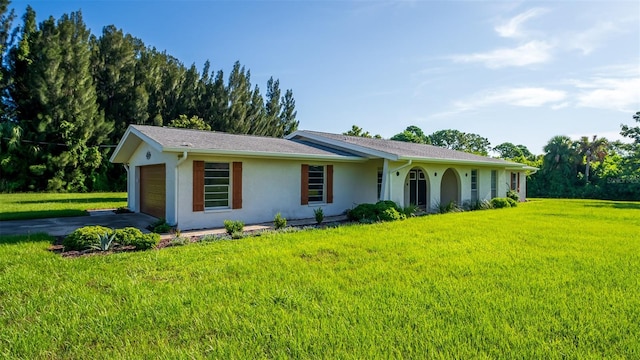 ranch-style house featuring a garage and a front lawn