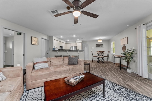 living room featuring ceiling fan and hardwood / wood-style floors