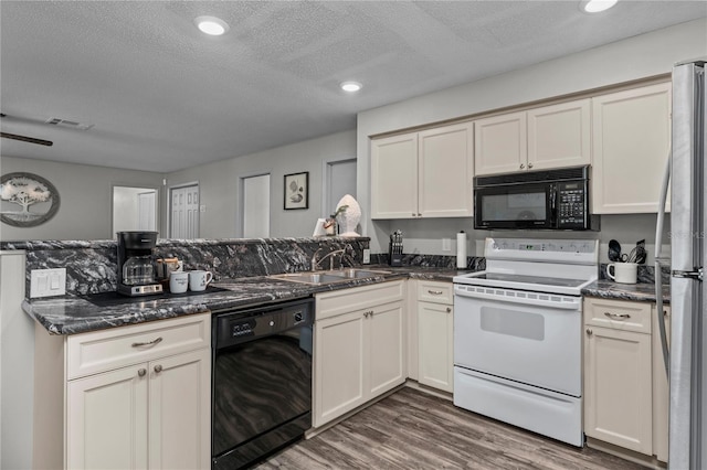 kitchen with a textured ceiling, dark hardwood / wood-style floors, kitchen peninsula, and black appliances