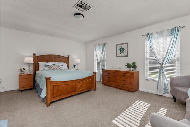 bedroom featuring light carpet and a textured ceiling