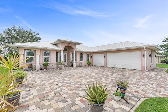 2416 SE 8th Ave, Cape Coral, FL 33990 - view of front of home with an attached garage, metal roof, decorative driveway, and stucco siding