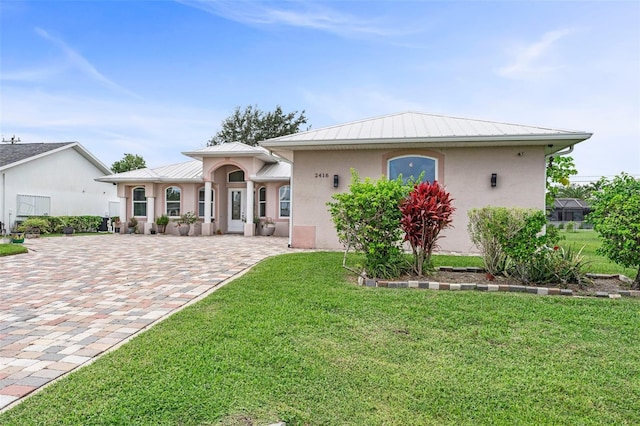 2416 SE 8th Ave, Cape Coral, FL 33990 - view of front of house with a standing seam roof, metal roof, a front yard, and stucco siding