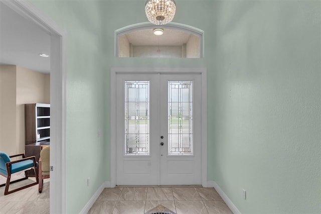 foyer entrance with french doors and an inviting chandelier