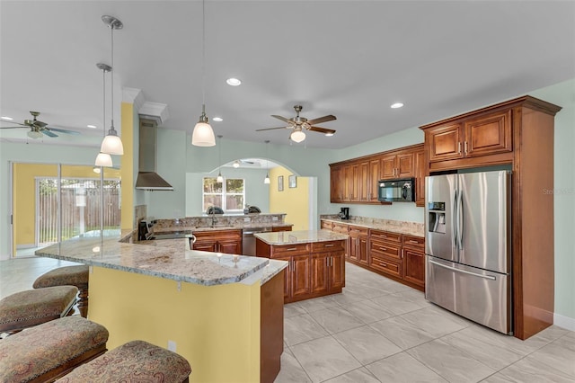 kitchen with a healthy amount of sunlight, wall chimney range hood, kitchen peninsula, pendant lighting, and appliances with stainless steel finishes