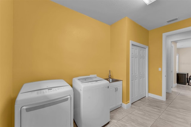 washroom with washer and clothes dryer, cabinets, and sink