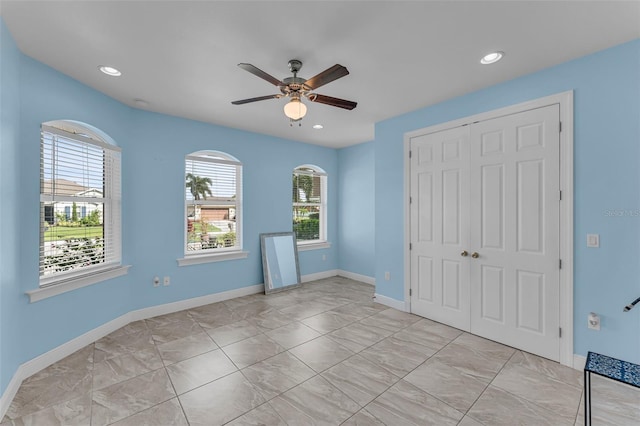 unfurnished bedroom with ceiling fan and a closet