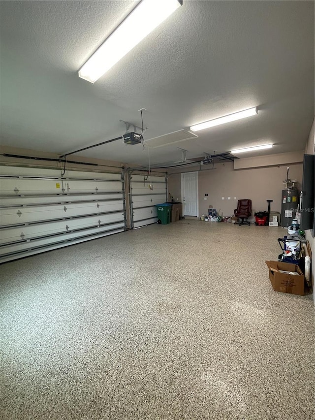 garage featuring electric water heater and a garage door opener