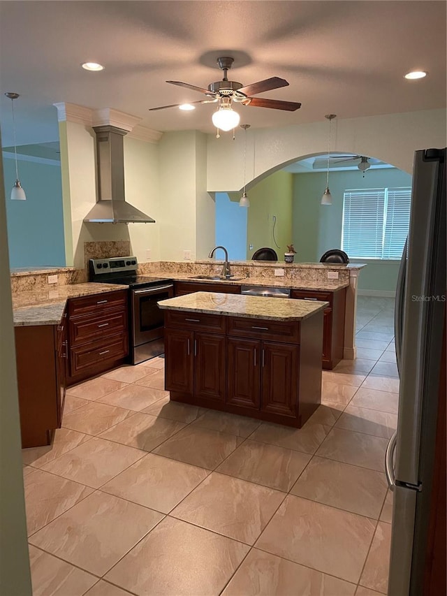 kitchen featuring wall chimney exhaust hood, kitchen peninsula, stainless steel appliances, and hanging light fixtures