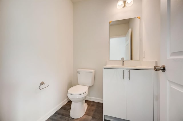 bathroom with hardwood / wood-style flooring, vanity, and toilet