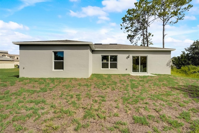 back of property featuring a lawn