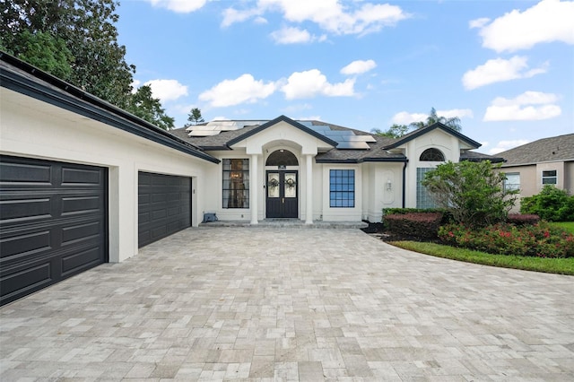 view of front facade with solar panels and a garage