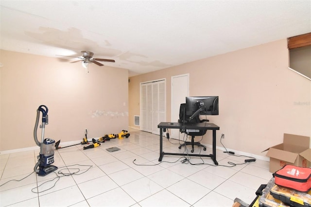 workout room with ceiling fan and light tile patterned floors