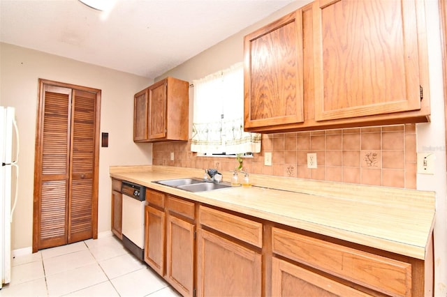 kitchen featuring light tile patterned floors, white appliances, sink, and tasteful backsplash