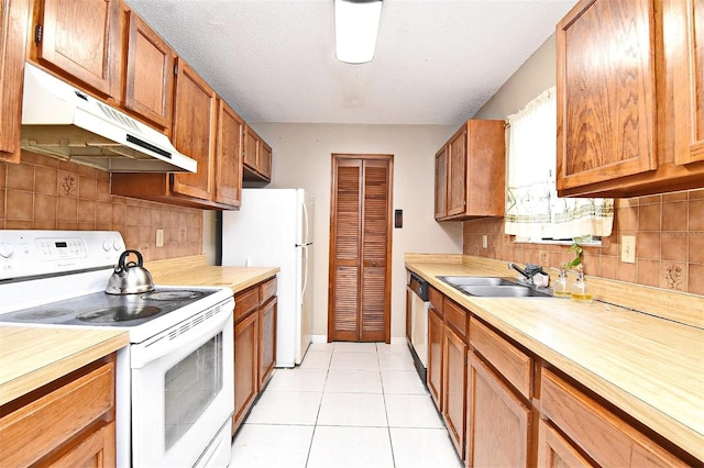 kitchen featuring light tile patterned floors, sink, white appliances, and tasteful backsplash