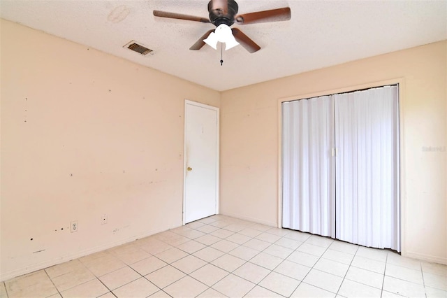 tiled spare room featuring ceiling fan and a textured ceiling