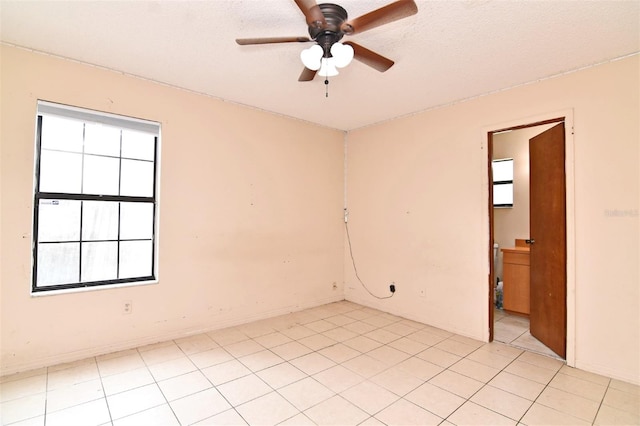 tiled spare room featuring ceiling fan and a textured ceiling