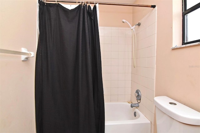 bathroom with shower / bath combo with shower curtain and toilet