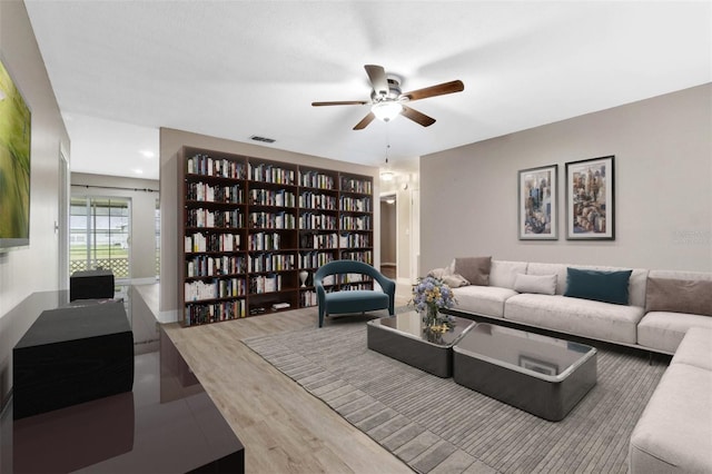 living room featuring wood-type flooring and ceiling fan