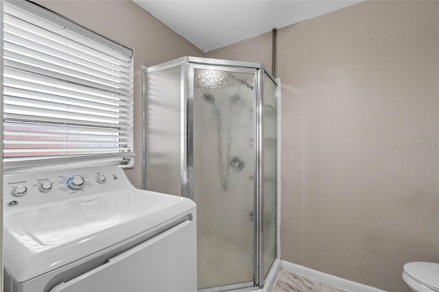 bathroom with vanity, toilet, an enclosed shower, and washer / dryer