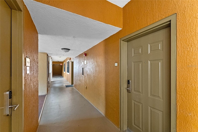 hallway with concrete floors and a textured ceiling