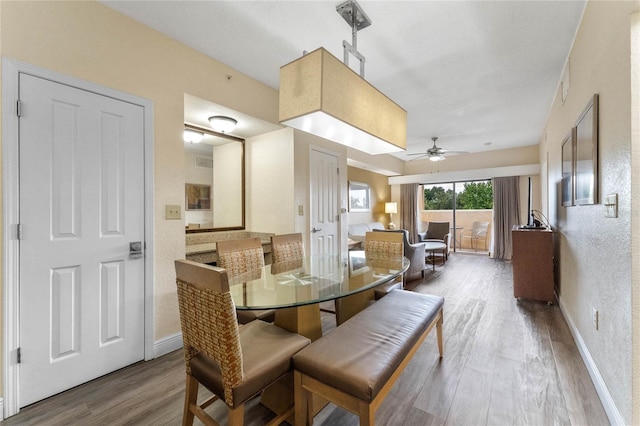 dining area with wood-type flooring and ceiling fan