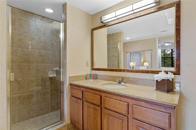 bathroom with a shower with shower door and vanity