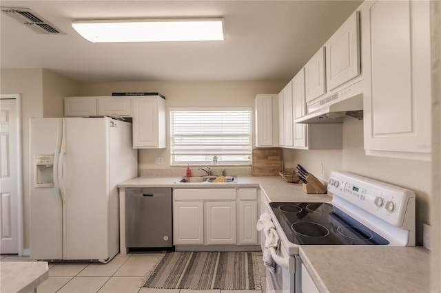 kitchen featuring white cabinets, sink, light tile patterned floors, and white appliances