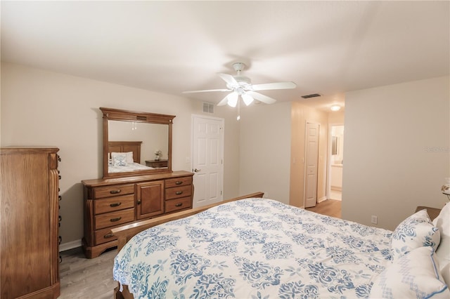 bedroom with light hardwood / wood-style flooring, ensuite bathroom, and ceiling fan