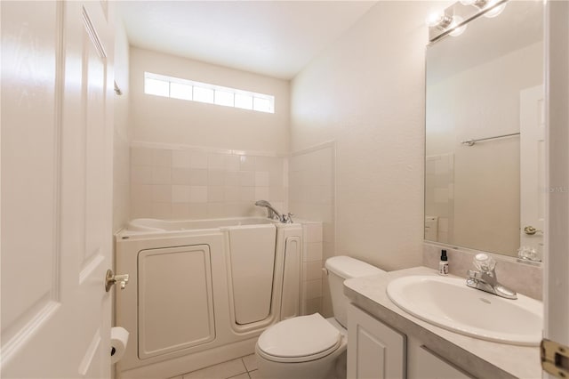 bathroom with a tub to relax in, toilet, vaulted ceiling, vanity, and tile patterned flooring