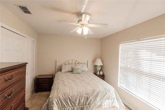 bedroom featuring a closet, light colored carpet, and ceiling fan