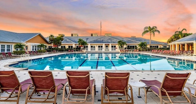 pool at dusk featuring a patio area