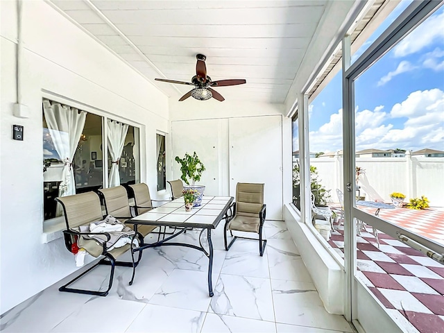 sunroom featuring ceiling fan and wooden ceiling