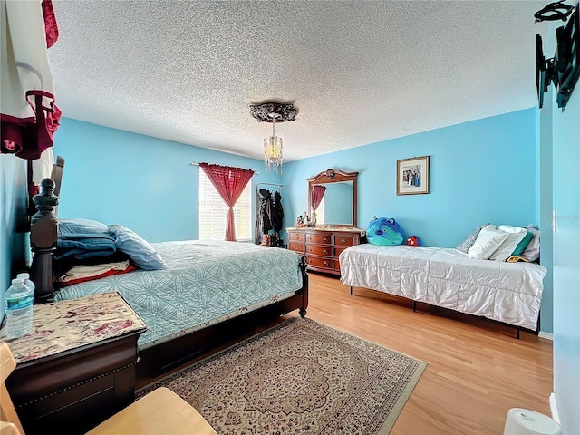 bedroom featuring a textured ceiling and light hardwood / wood-style flooring