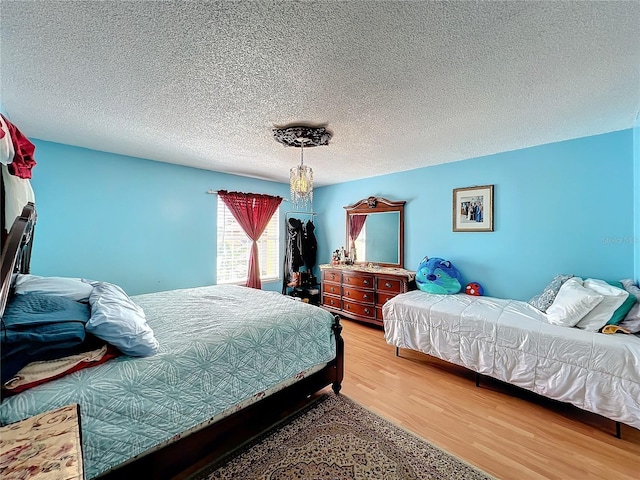 bedroom with hardwood / wood-style flooring and a textured ceiling