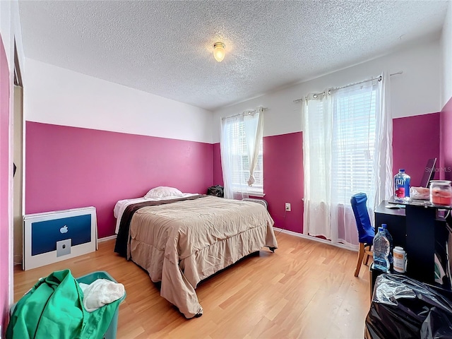 bedroom featuring wood-type flooring and a textured ceiling