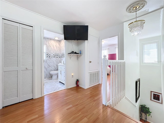 corridor featuring hardwood / wood-style floors and a chandelier