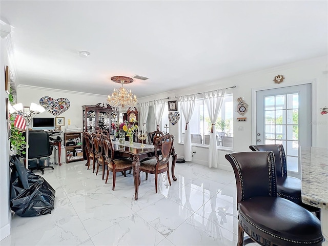 dining room with ornamental molding and a notable chandelier