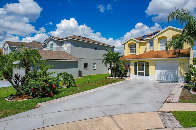 view of front of property featuring solar panels, a front yard, and a garage