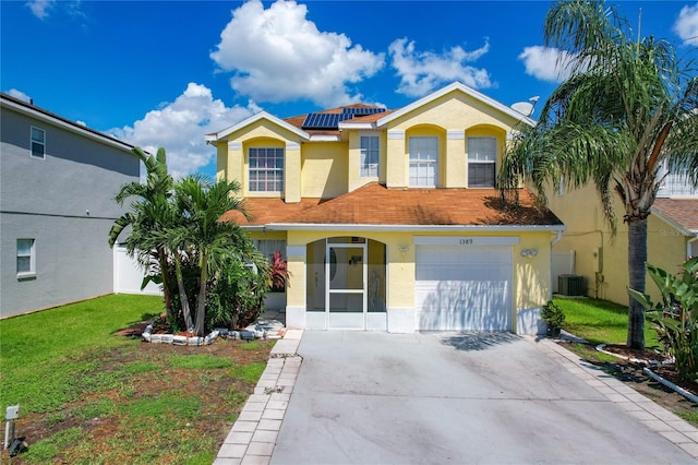 view of front of house featuring solar panels, a front yard, and a garage