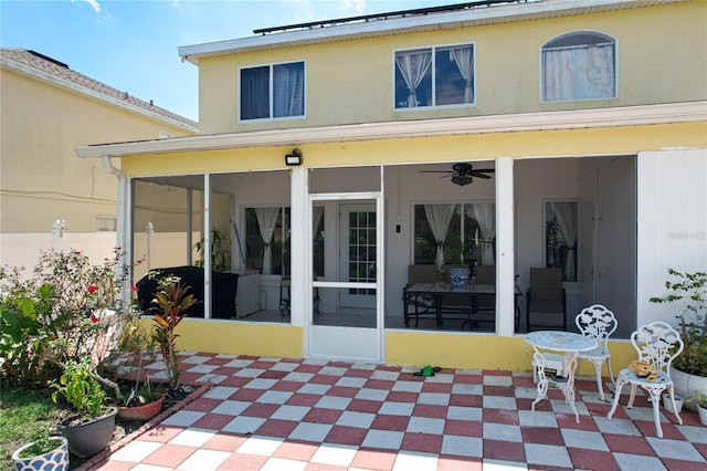 rear view of property with ceiling fan, a sunroom, and a patio area