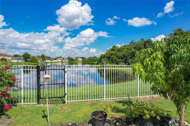 view of pool with a lawn and a water view