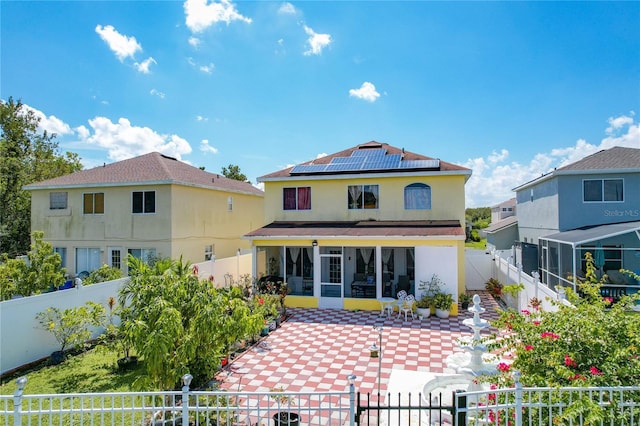 rear view of property with solar panels and a sunroom