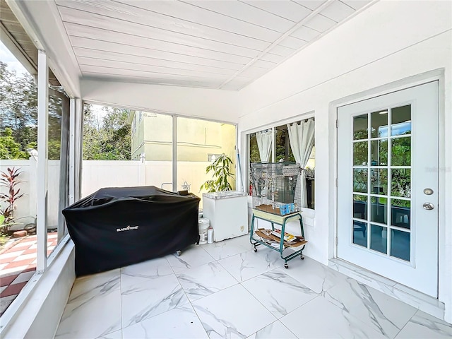 sunroom / solarium featuring lofted ceiling and wood ceiling